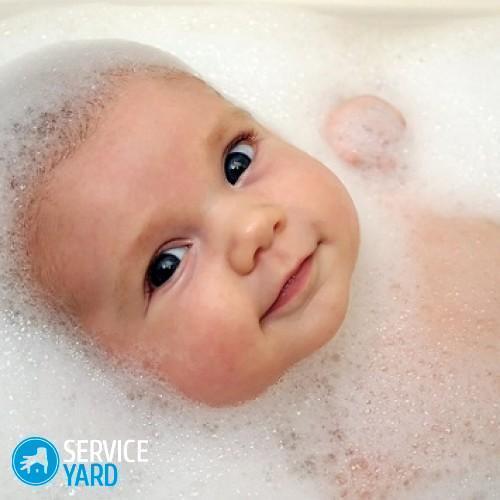 A baby in a bathtub with soap foam.